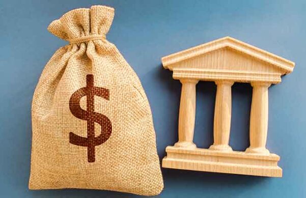 burlap bag with dollar sign and wooden building facade on blue background