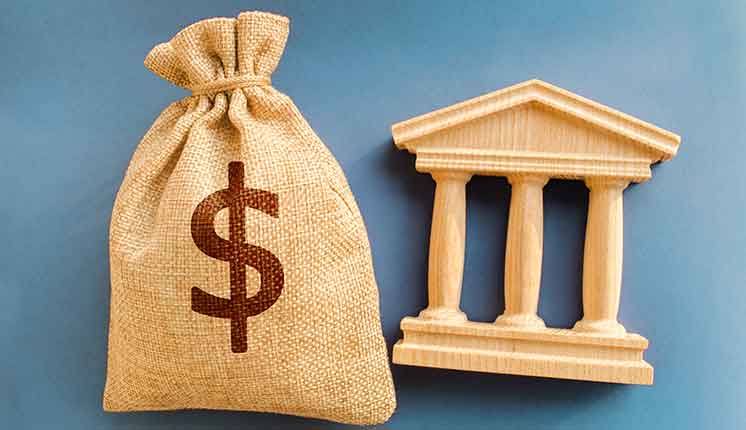 burlap bag with dollar sign and wooden building facade on blue background