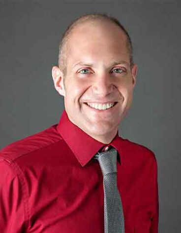 A person in a red shirt and tie