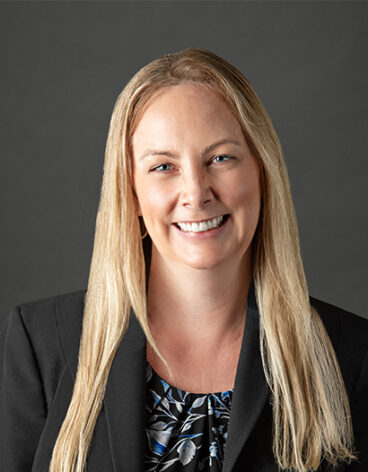 A person with blonde hair wearing a black jacket