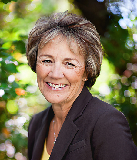 Person smiling in front of trees