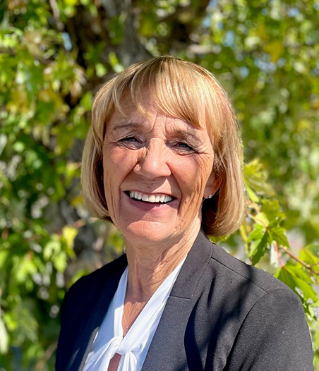 Person smiling in front of trees