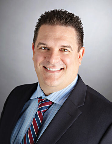 Image of a person in a suit smiling