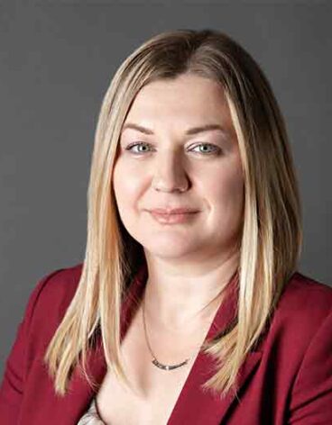 A person with blonde hair wearing a red jacket