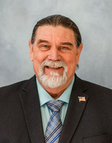 Person smiling in front of a blank background