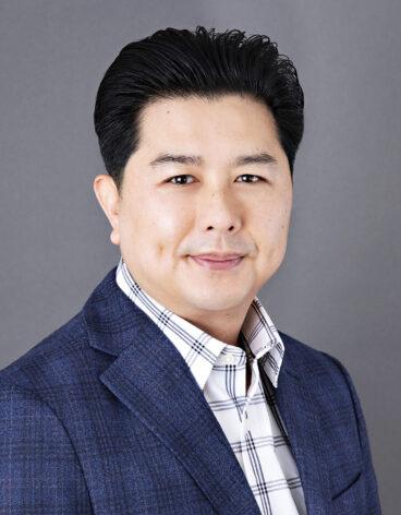 Man with short dark hair and a blue blazer.