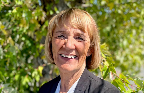 Person smiling in front of trees