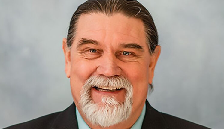 Person smiling in front of a blank background