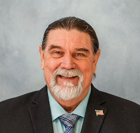 Person smiling in front of a blank background
