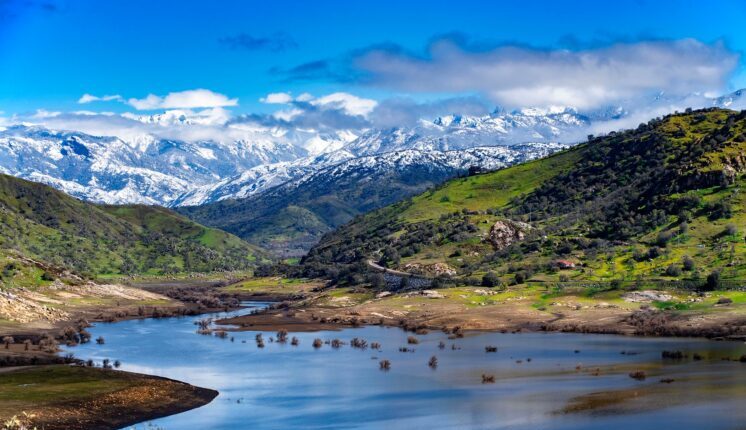 A river running through a valley with mountains in the background