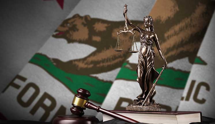 scales of justice and gavel with California State flag as background