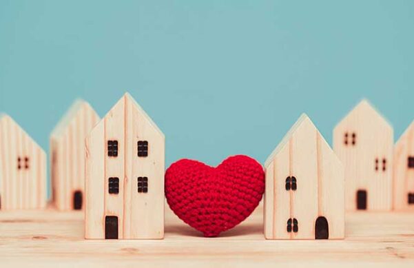 display of small wooden houses with a crocheted heart between them