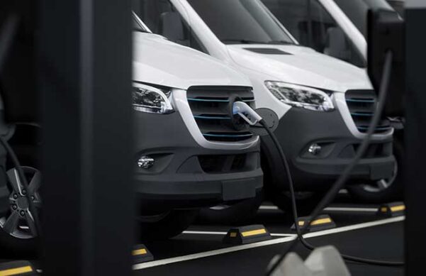 vans plugged into electric vehicle charging stations