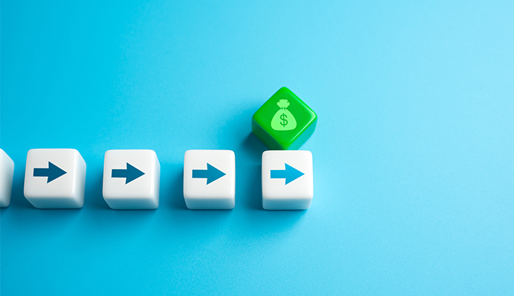 five dice on blue background. four dice in straight line with arrows pointing right and one die, green with money bag etched on it, resting above the last arrow