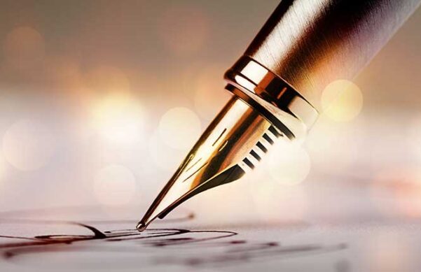 pen signing on a piece of paper