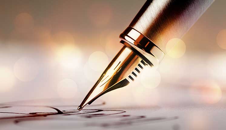 pen signing on a piece of paper