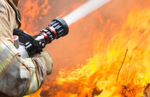 firefighter with hose fighting wildfire