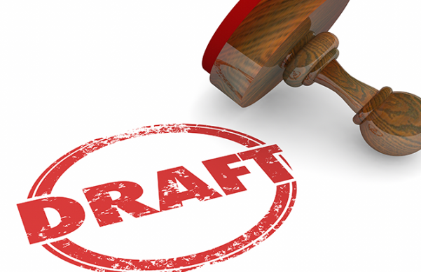 red letters encircled in red sitting next to a stamp with a wooden handle