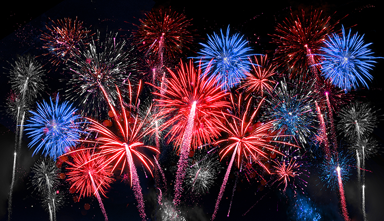 fireworks of red, white, and blue illuminated in the night sky.