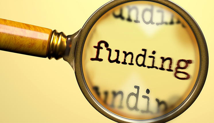 text under a magnifying glass, against a yellow background.