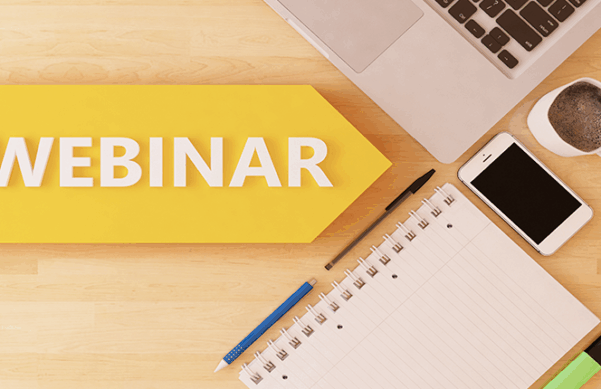 yellow arrow announcing a webinar points to computer, phone, notebook, and writing utensils on desk